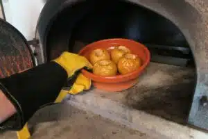 Pommes confites dans un plat en terre à la sortie du four à bois