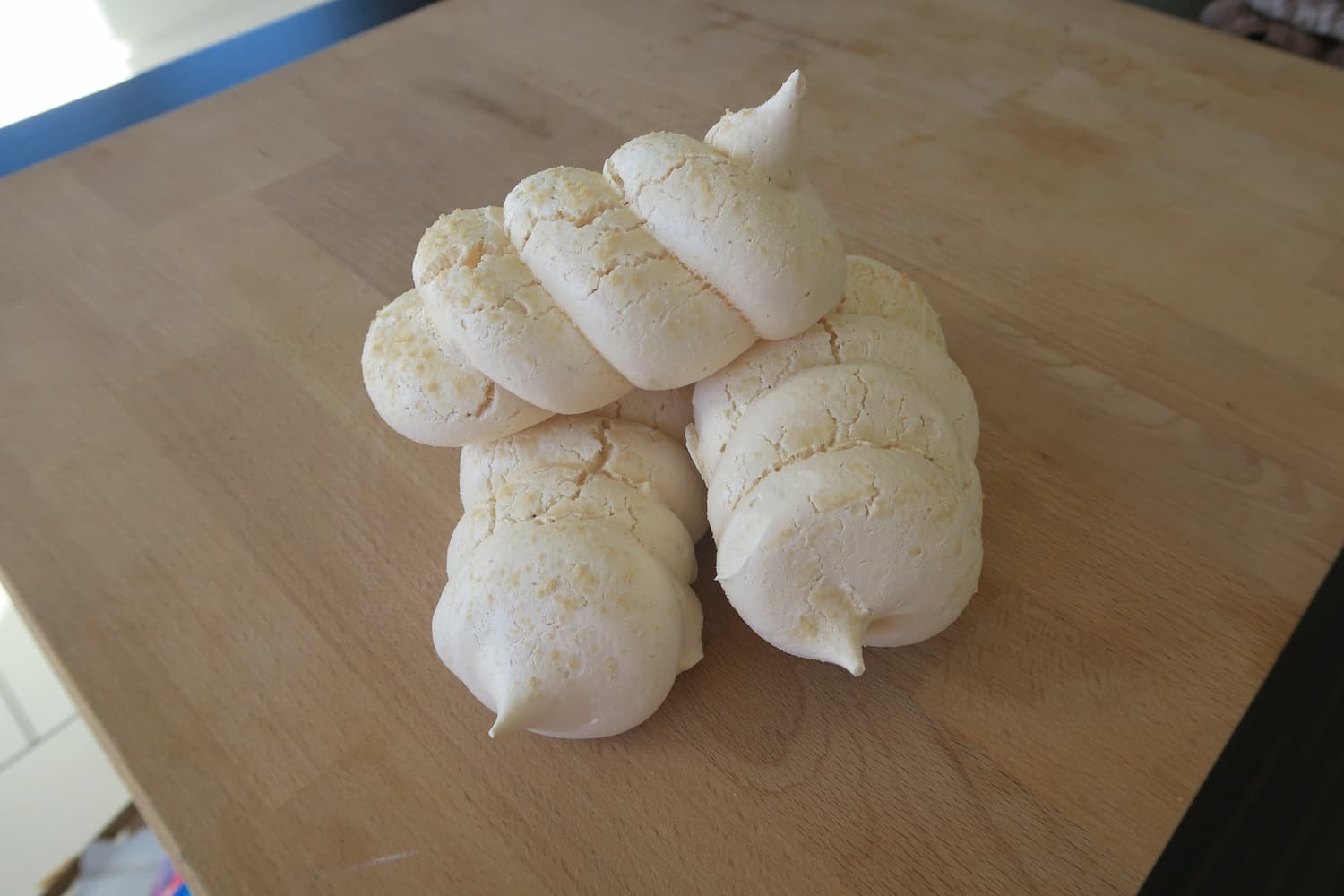Meringues françaises cuites au four à bois, empilées sur une planche