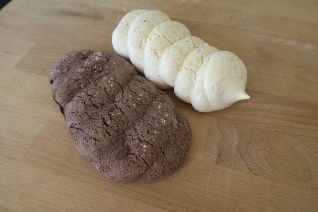 Meringues cuites au chocolat et nature, posées sur une planche