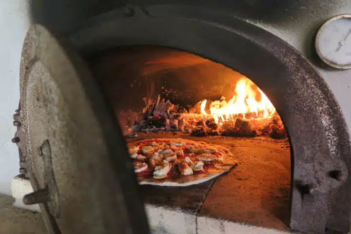 Pizza en cuisson dans four à bois