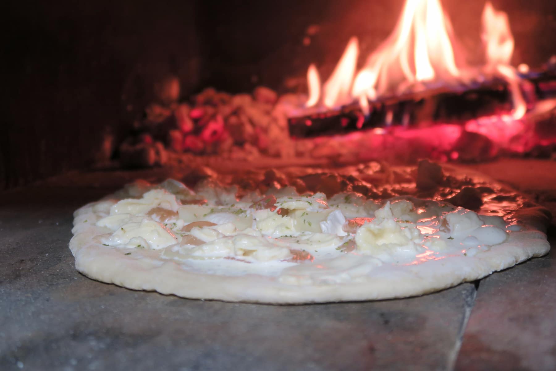 Pizza blanche au four à bois, poulet chèvre et miel