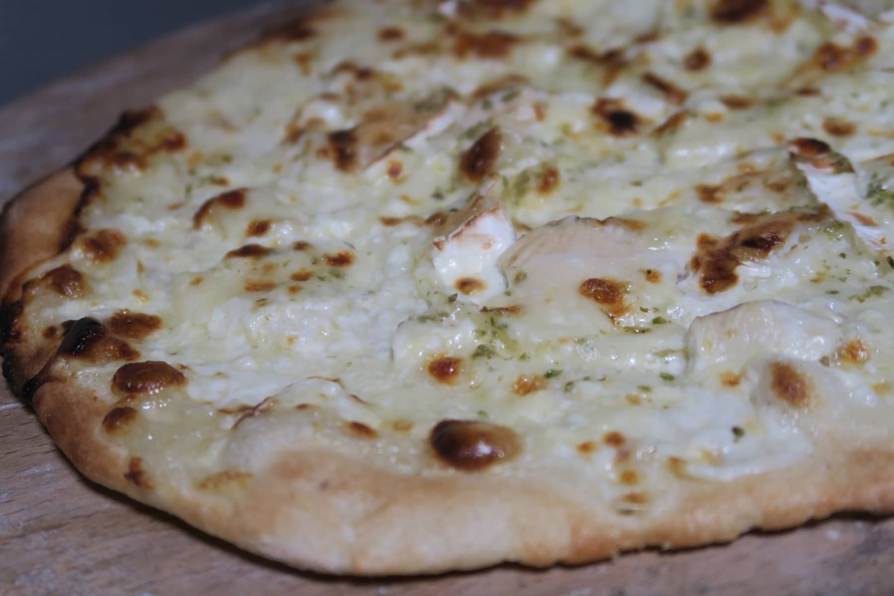 Pizza poulet, chèvre et miel à la sortie du four